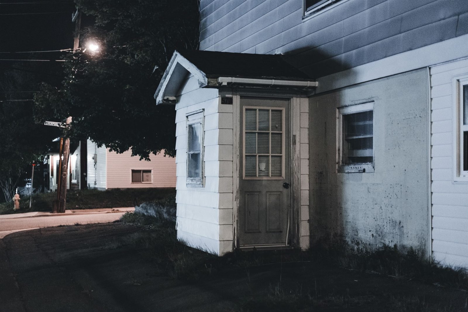 A small house at night with a dark porch and no lights showing