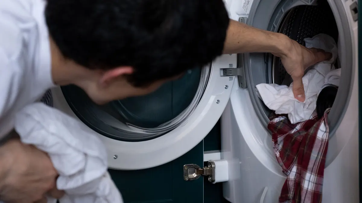 Man loading laundry into a front-loading washer