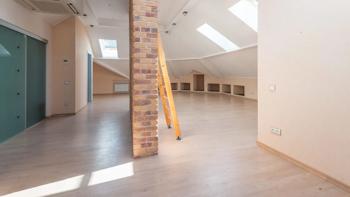 Bright attic room with wood floors and skylights
