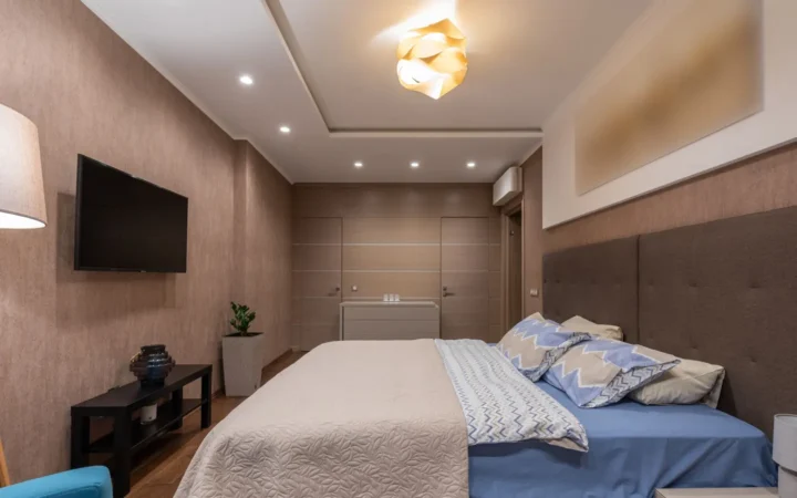 Hotel-style bedroom with a made bed and bedside tables