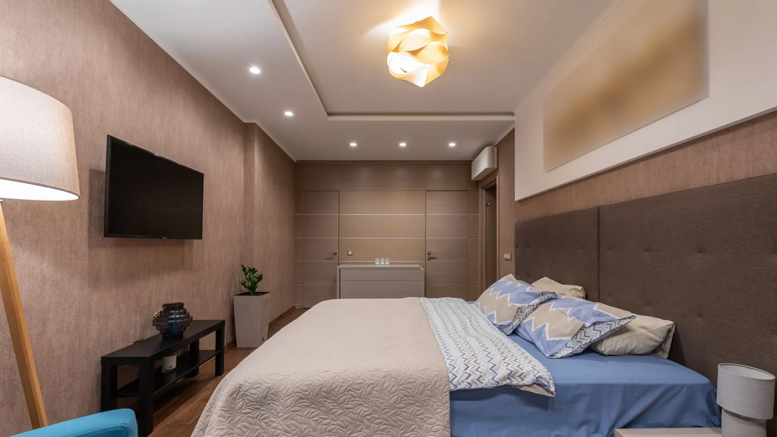 Hotel-style bedroom with a made bed and bedside tables
