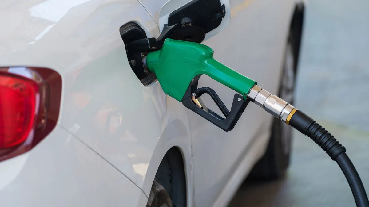 Green fuel nozzle in the filler of a white car