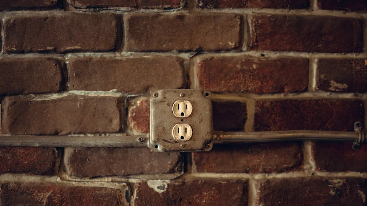 Old electrical outlet on a brick wall