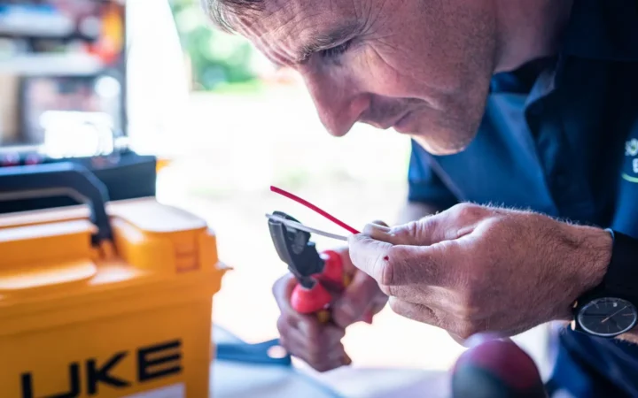 Electrician cutting and stripping wires with pliers