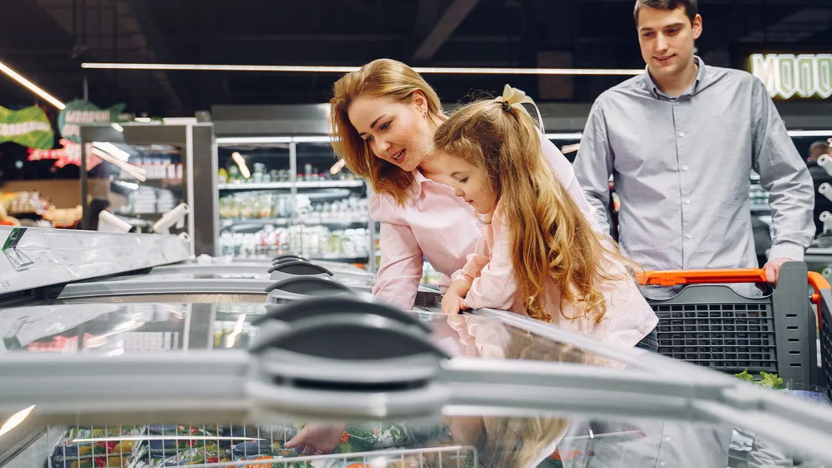 Family looking into a supermarket chest freezer