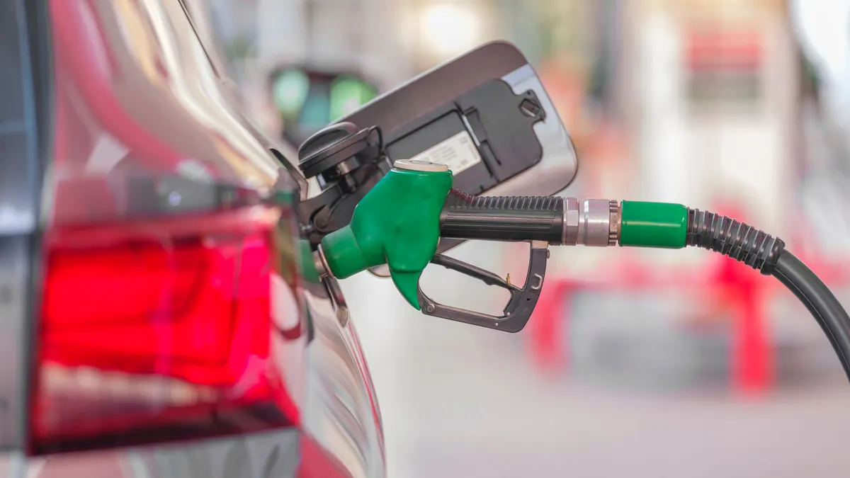 Fuel nozzle refueling a vehicle at a gas station pump