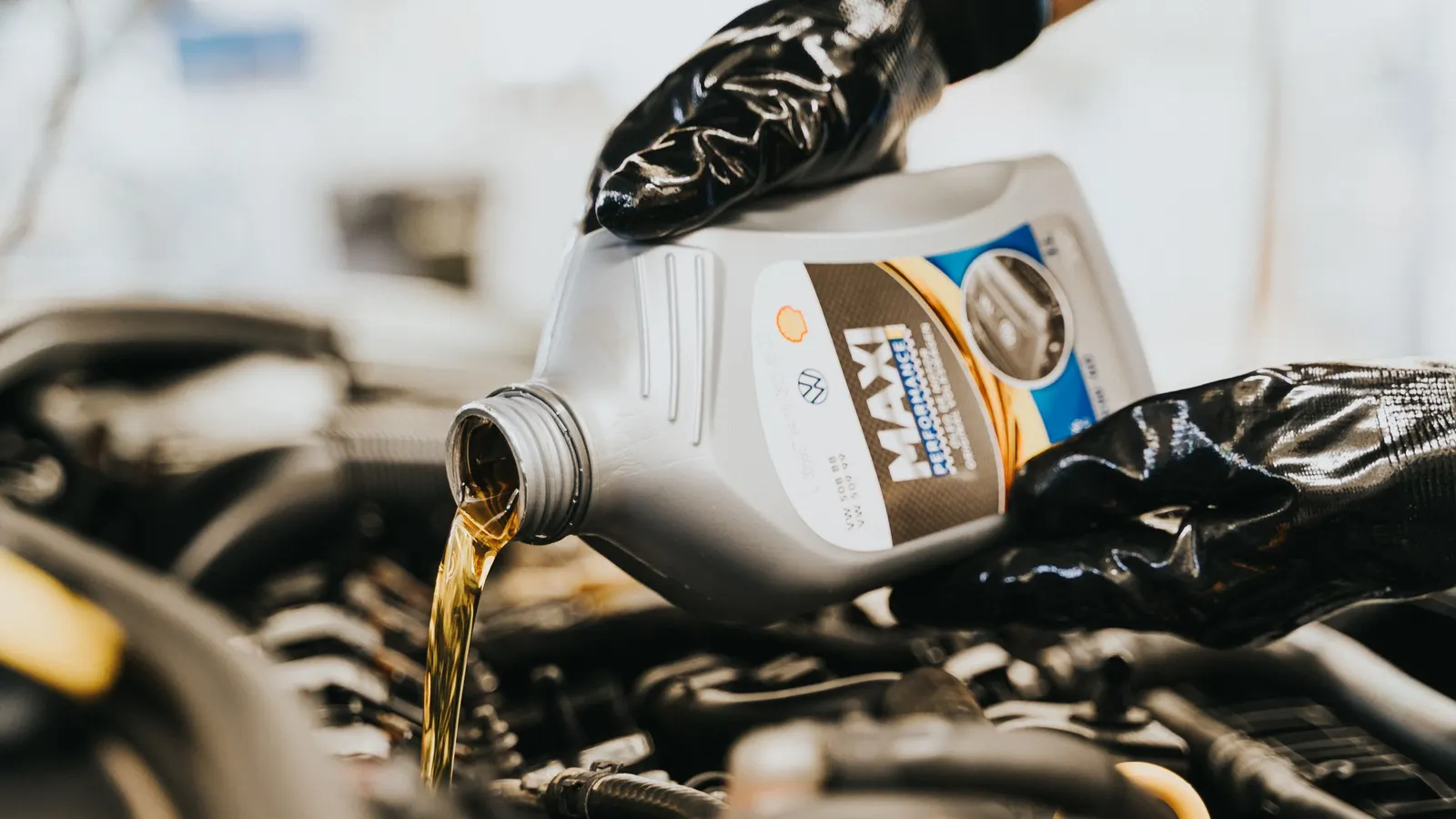 Fresh motor oil being poured into an engine