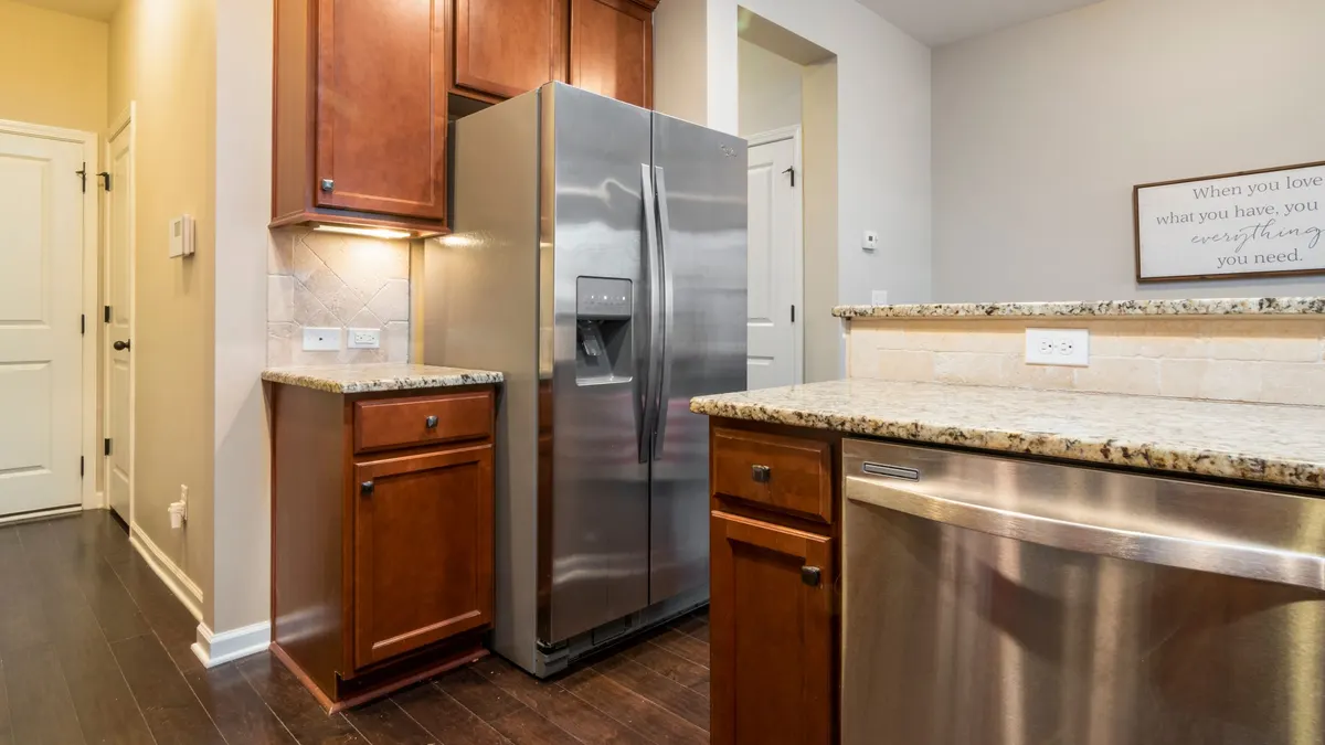 Stainless steel side-by-side refrigerator in a kitchen with wood cabinets