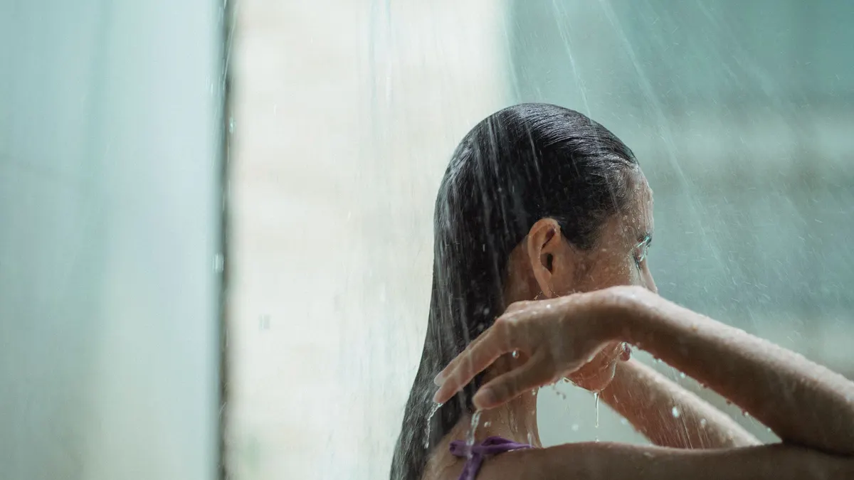 Woman rinsing her hair in a shower
