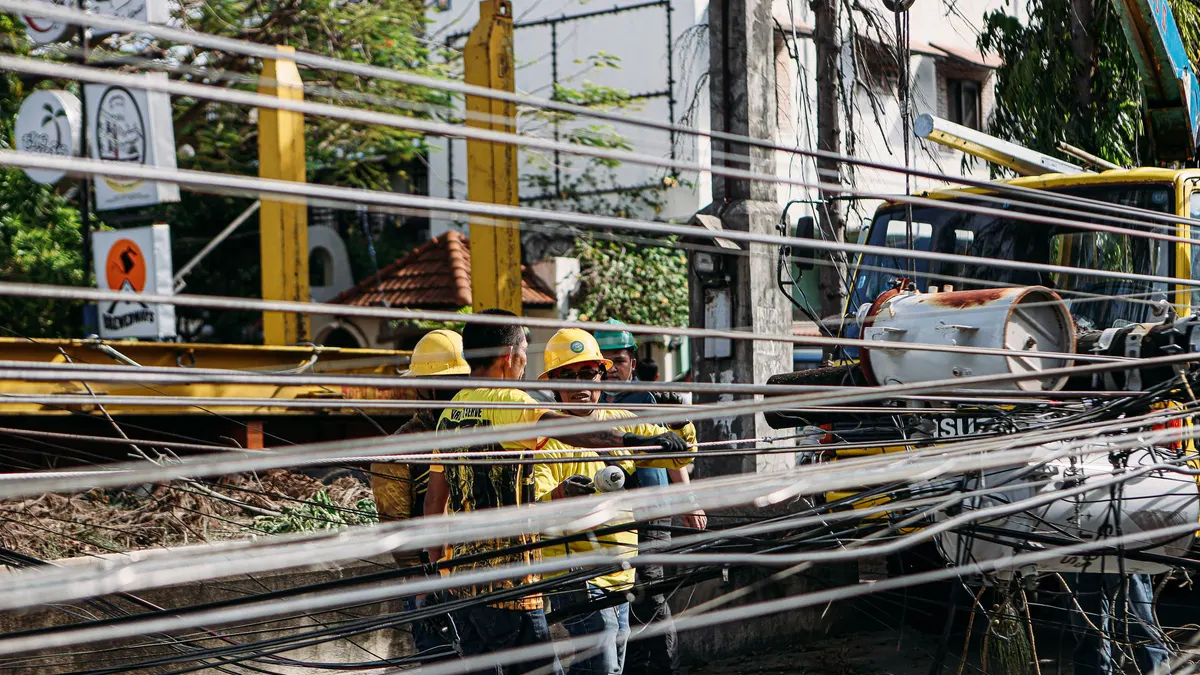 Utility crew repairing damaged power lines on a street