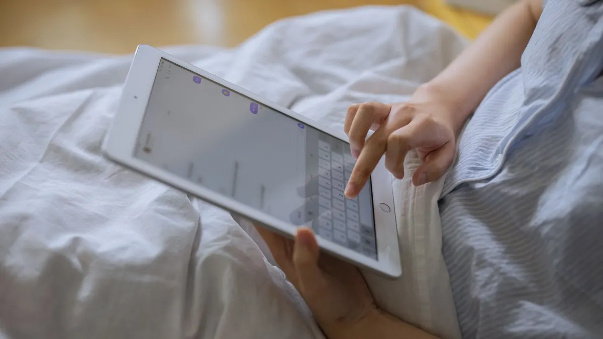 Person using a tablet in bed