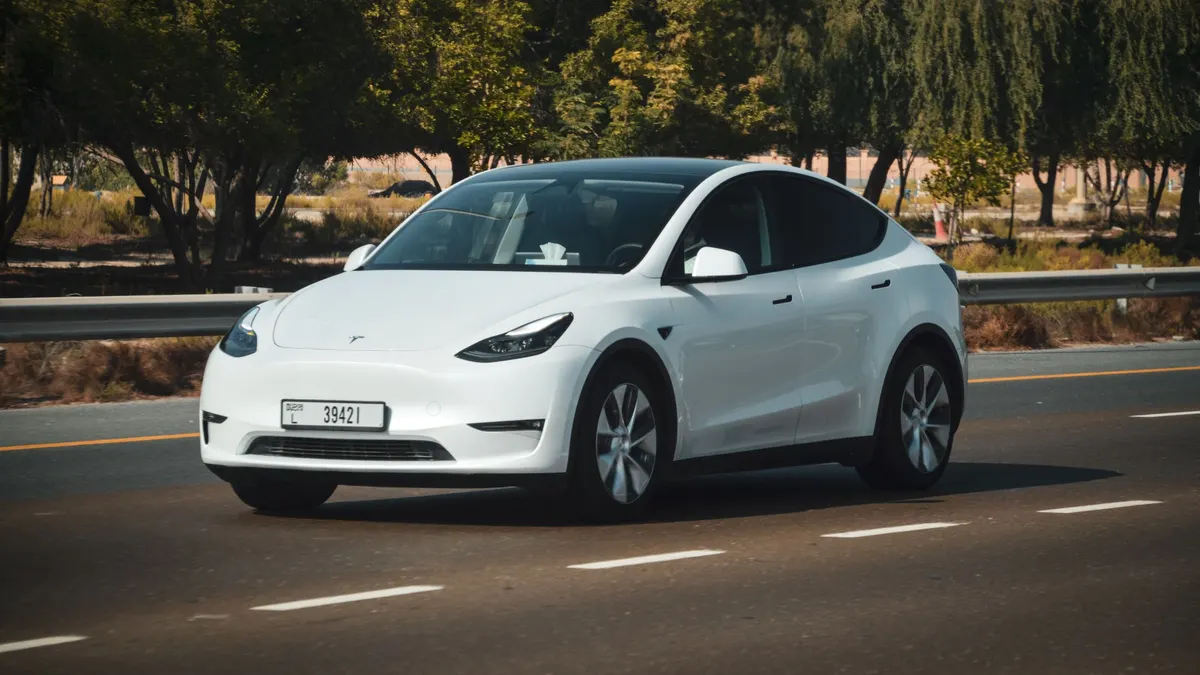 White electric crossover driving on a road
