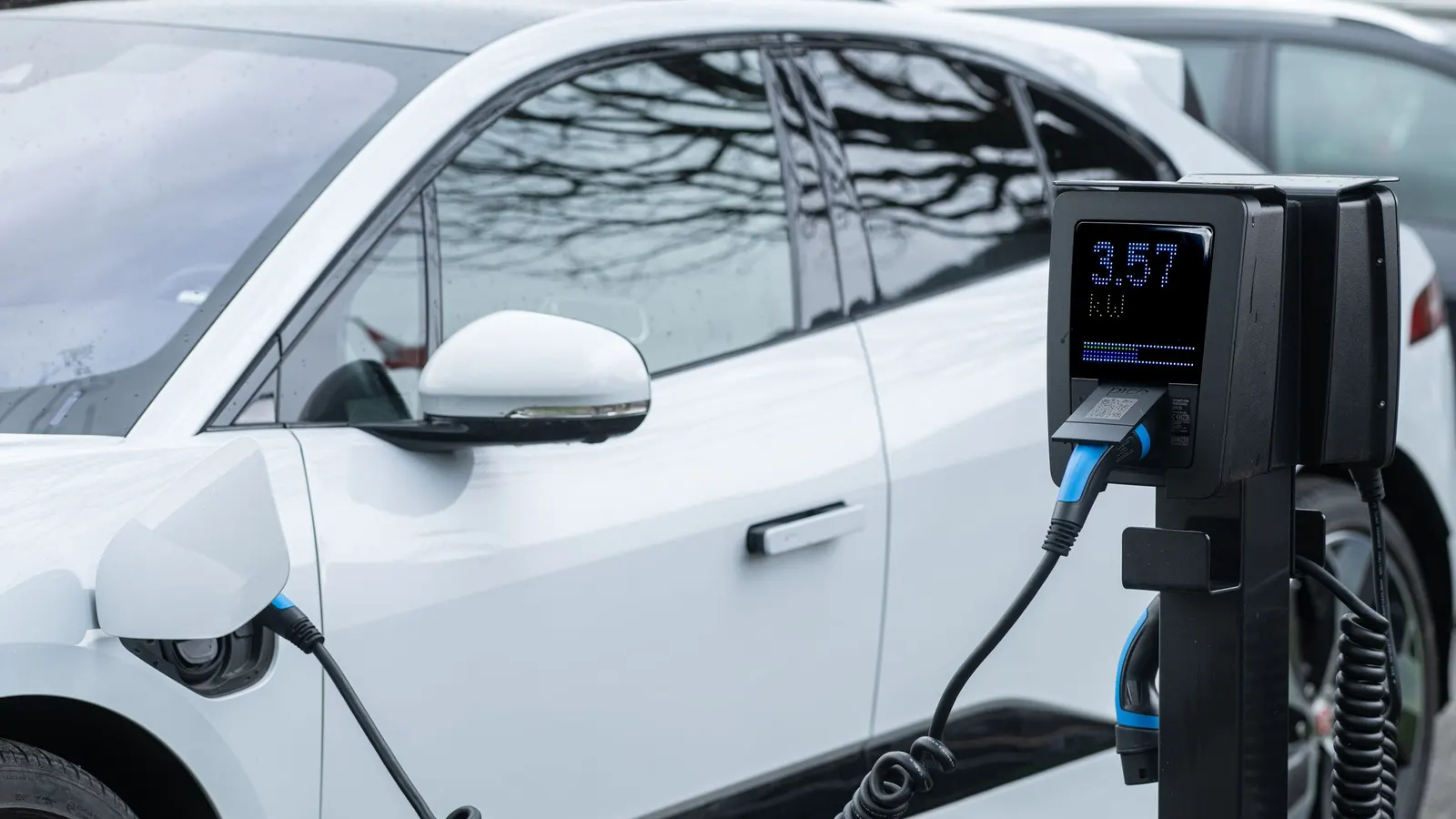 White electric car charging from a pedestal charger
