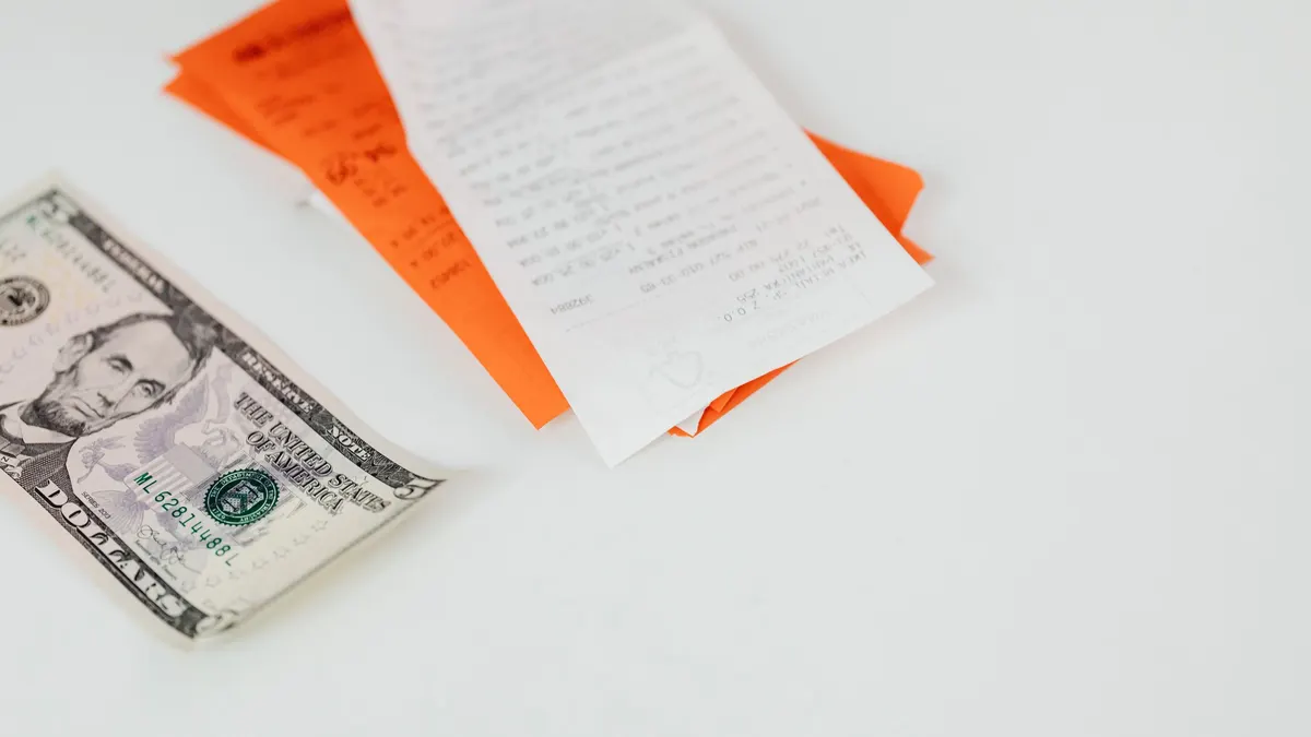 Dollar bills and receipts on a white desk