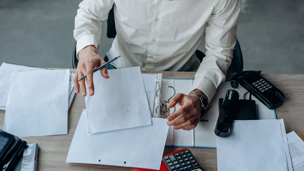 Person reviewing paperwork at a desk