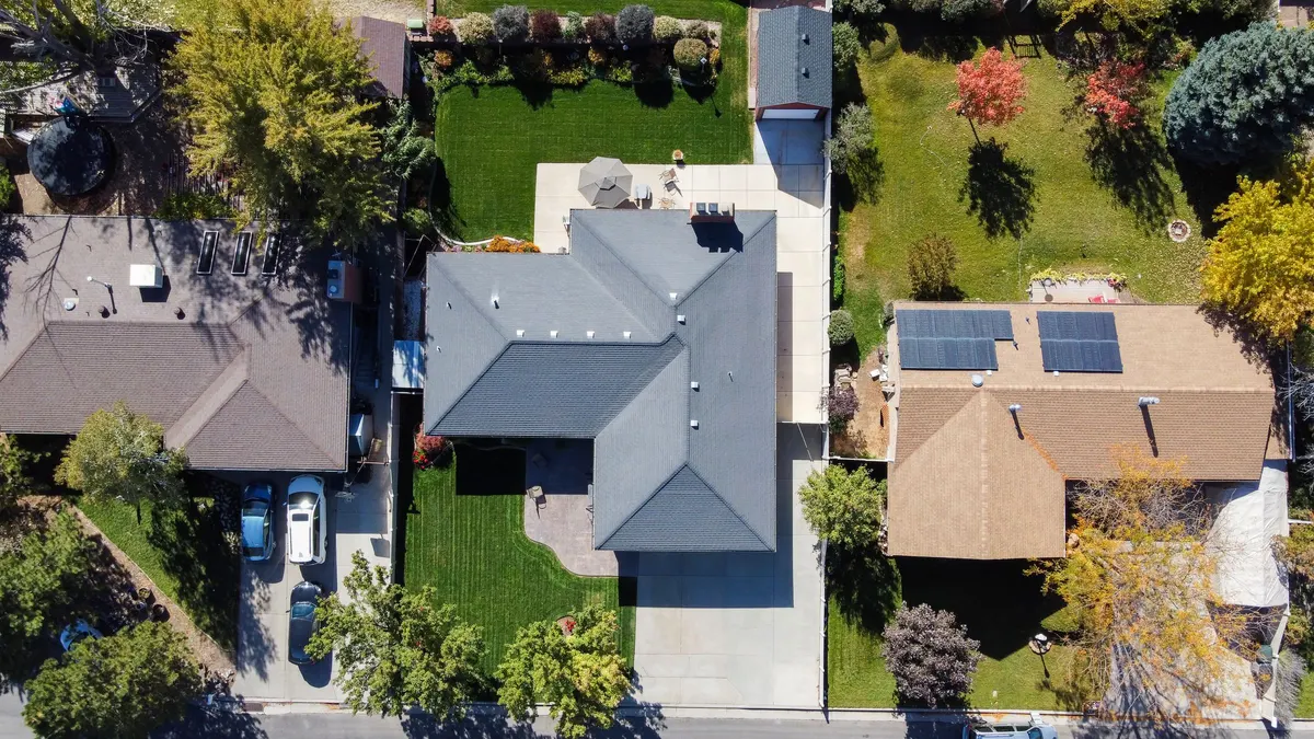 Aerial view of suburban houses, one with rooftop solar