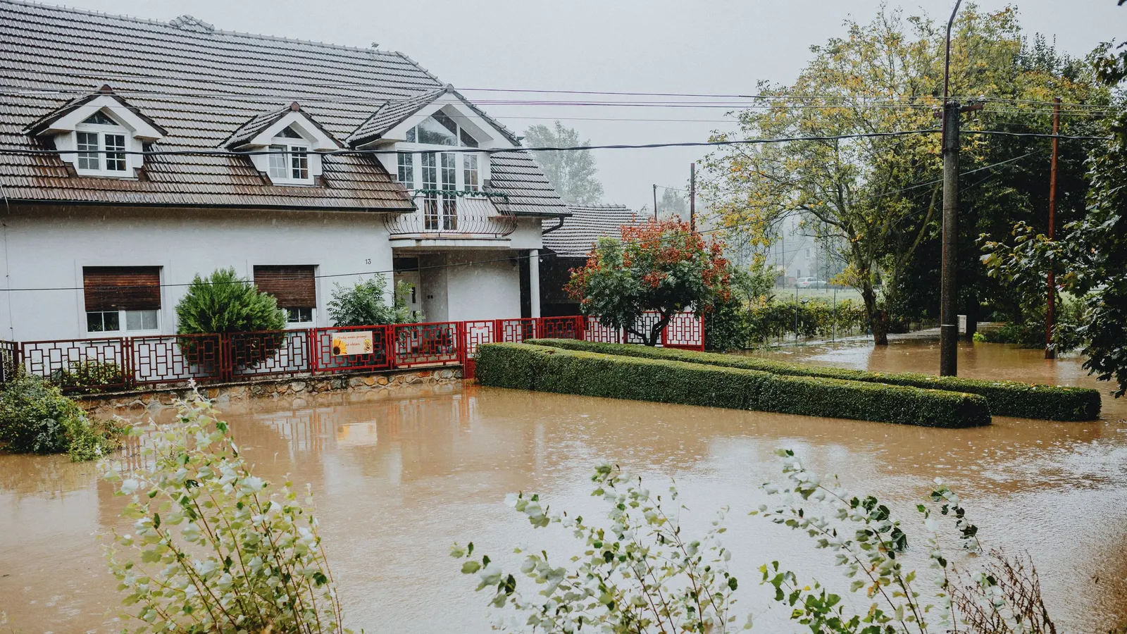 Floodwater covering the front yard of a house