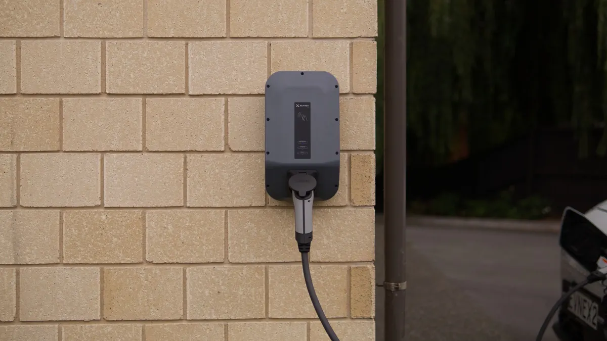 Wall-mounted EV charger on a light brick wall