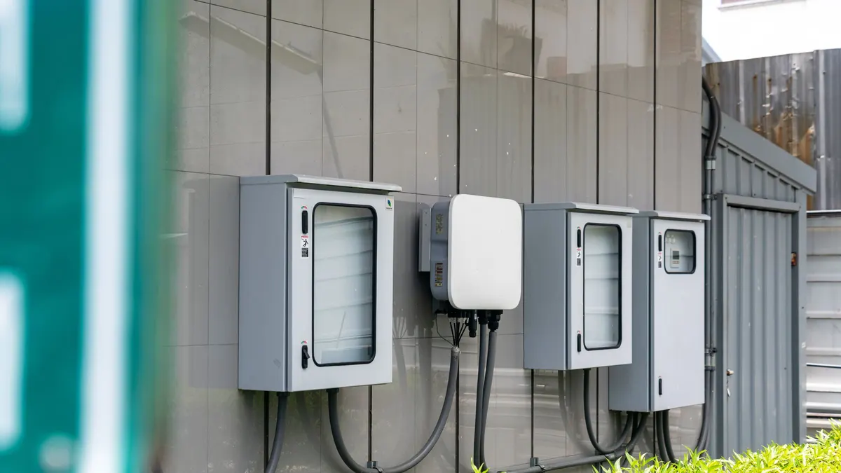 Gray electrical disconnect boxes mounted on a house exterior