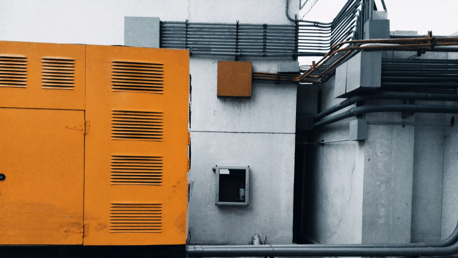 Large yellow generator enclosure installed outdoors beside a building